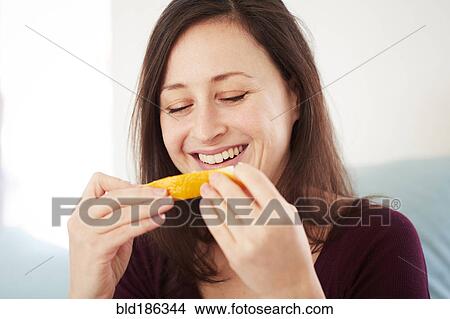 Mixed race woman eating orange View Large Photo Image Picture - Mixed race woman eating orange. Fotosearch