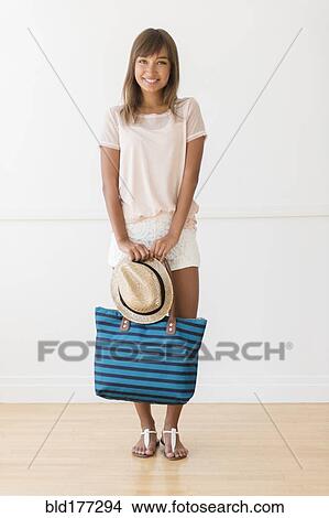 Mixed race woman holding tote bag View Large Photo Image Picture - Mixed race woman holding tote bag. Fotosearch