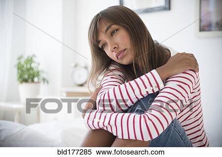 Mixed race woman hugging her knees View Large Photo Image Stock Photography - Mixed race woman hugging her knees. Fotosearch