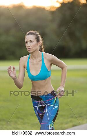 Mixed race woman jogging on road View Large Photo Image Stock Image - Mixed race woman jogging on road. Fotosearch