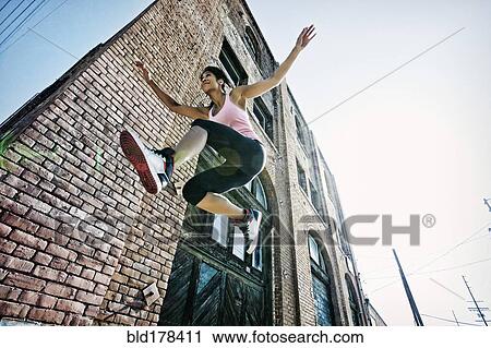 Mixed race woman jumping outdoors View Large Photo Image Stock Image - Mixed race woman jumping outdoors. Fotosearch