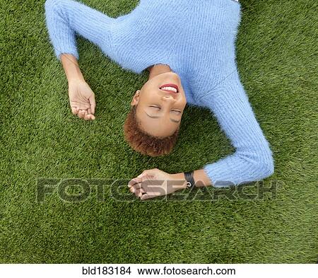 Mixed race woman laying in grass View Large Photo Image Picture - Mixed race woman laying in grass. Fotosearch