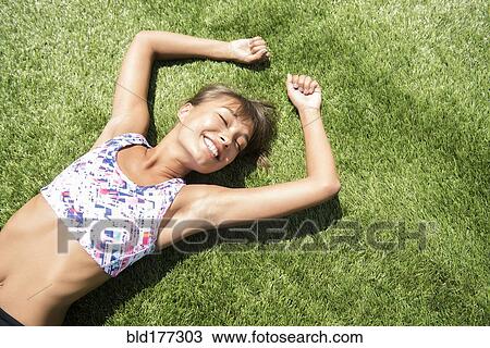 Mixed race woman laying in grass View Large Photo Image Stock Image - Mixed race woman laying in grass. Fotosearch