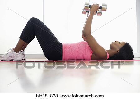 Mixed race woman lifting weights View Large Photo Image Stock Photo - Mixed race woman lifting weights. Fotosearch