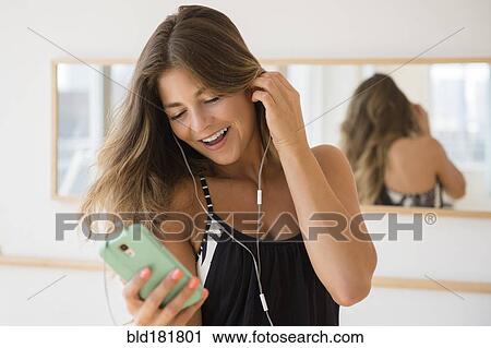 Mixed race woman listening to headphones View Large Photo Image Stock Image - Mixed race woman listening to headphones. Fotosearch