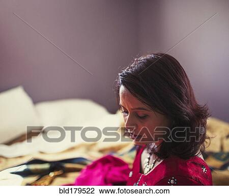 Stock Image - Mixed race woman looking down. Fotosearch