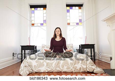 Mixed race woman meditating in bedroom View Large Photo Image Stock Image - Mixed race woman meditating in bedroom. Fotosearch