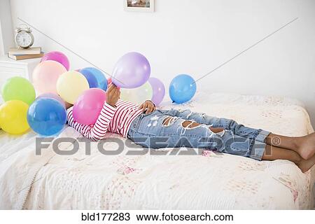 Mixed race woman playing with balloons View Large Photo Image Stock Image - Mixed race woman playing with balloons. Fotosearch