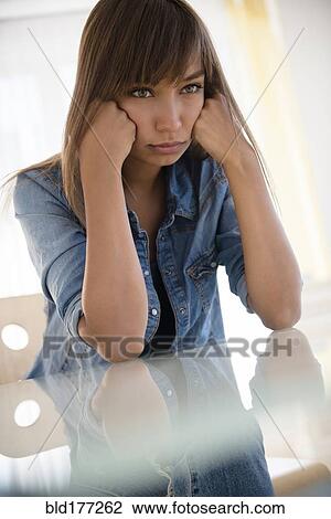 Mixed race woman pouting at table View Large Photo Image Stock Image - Mixed race woman pouting at table. Fotosearch