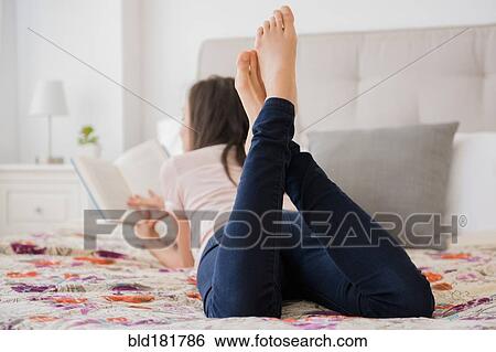 Mixed race woman reading book on bed View Large Photo Image Stock Photograph - Mixed race woman reading book on bed. Fotosearch