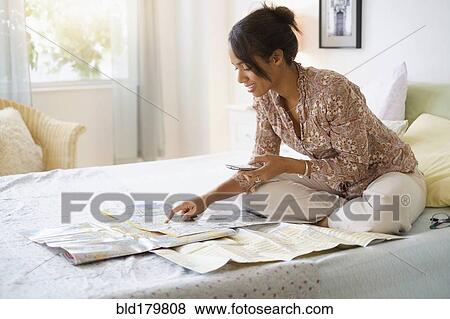 Mixed race woman reading map in bed View Large Photo Image Stock Photo - Mixed race woman reading map in bed. Fotosearch