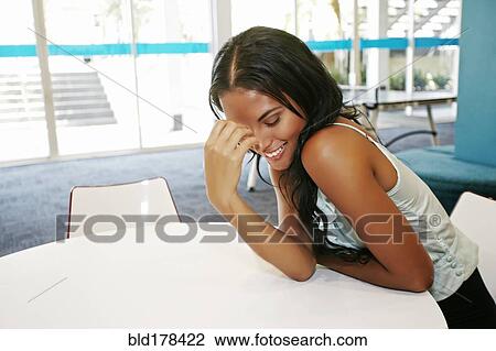 Mixed race woman sitting at table View Large Photo Image Stock Image - Mixed race woman sitting at table. Fotosearch