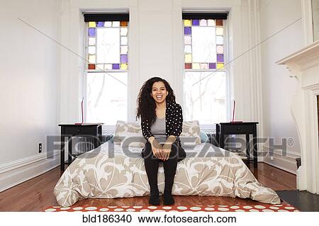 Mixed race woman sitting in bedroom View Large Photo Image Stock Image - Mixed race woman sitting in bedroom. Fotosearch