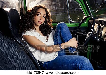Stock Photo - Mixed race woman sitting in car. Fotosearch