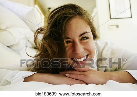 Mixed race woman smiling on bed View Large Photo Image Stock Photo - Mixed race woman smiling on bed. Fotosearch