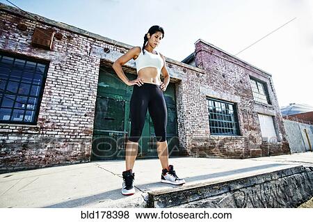 Stock Photo - Mixed race woman standing on sidewalk. Fotosearch