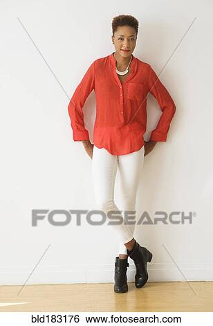 Stock Photograph - Mixed race woman standing with hands on hips. Fotosearch