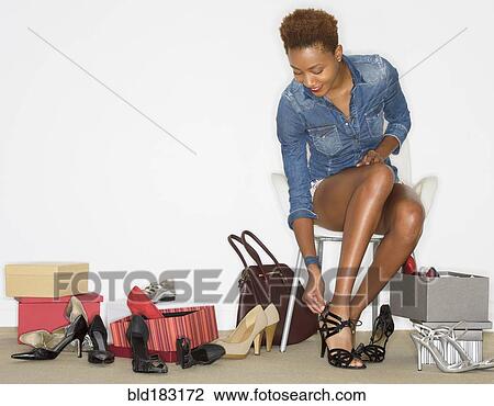 Mixed race woman trying on new shoes View Large Photo Image Stock Image - Mixed race woman trying on new shoes. Fotosearch