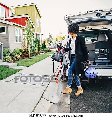 Stock Photo - Mixed race woman unpacking car. Fotosearch