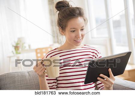 Stock Image - Mixed race woman using digital tablet. Fotosearch