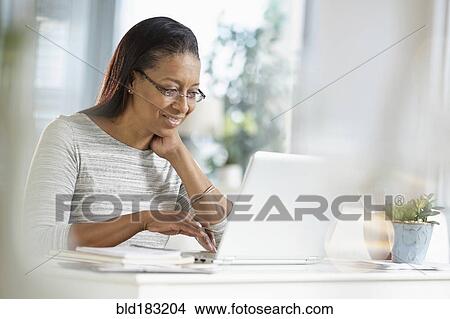 Mixed race woman using laptop View Large Photo Image Picture - Mixed race woman using laptop. Fotosearch