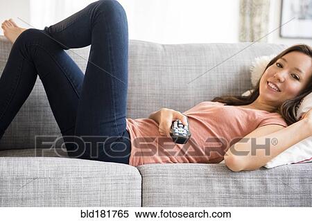 Stock Photography - Mixed race woman watching television. Fotosearch