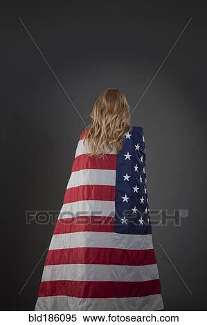 Stock Photography - Mixed race woman wrapped in American flag. Fotosearch