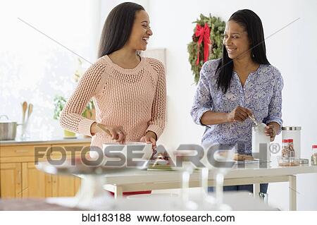 Stock Photo - Mother and daughter baking in kitchen. Fotosearch