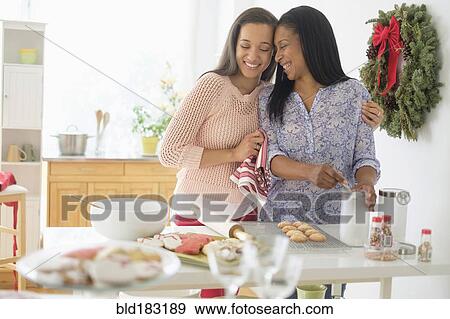 Stock Photo - Mother and daughter baking in kitchen. Fotosearch