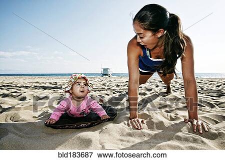 Mother and daughter doing push-ups at beach View Large Photo Image Stock Photo - Mother and daughter doing push-ups at beach. Fotosearch