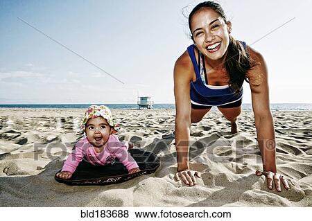 Mother and daughter doing push-ups at beach View Large Photo Image Stock Photo - Mother and daughter doing push-ups at beach. Fotosearch