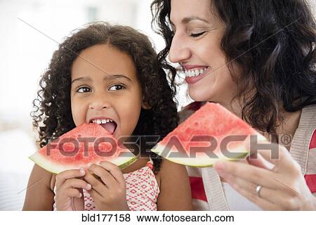 Mother and daughter eating watermelon View Large Photo Image Stock Photo - Mother and daughter eating watermelon. Fotosearch