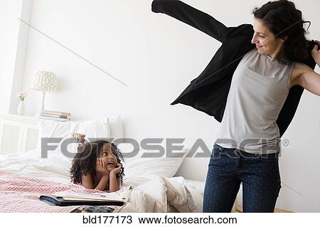 Stock Image - Mother and daughter getting ready in bedroom. Fotosearch