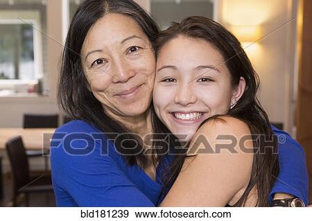 Stock Photo - Mother and daughter hugging indoors. Fotosearch