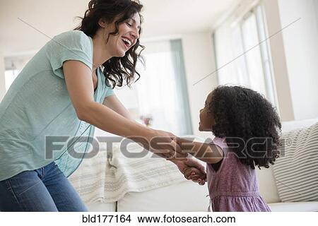 Mother and daughter playing in living room View Large Photo Image Picture - Mother and daughter playing in living room. Fotosearch