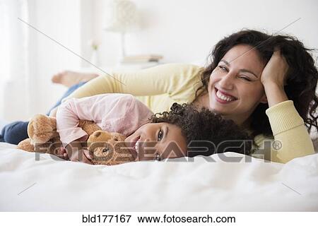 Mother and daughter smiling on bed View Large Photo Image Stock Photo - Mother and daughter smiling on bed. Fotosearch