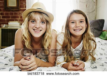 Mother and daughter smiling on bed View Large Photo Image Stock Photo - Mother and daughter smiling on bed. Fotosearch