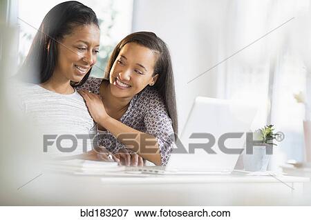 Mother and daughter using laptop View Large Photo Image Stock Photo - Mother and daughter using laptop. Fotosearch