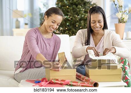Picture - Mother and daughter wrapping Christmas gifts. Fotosearch
