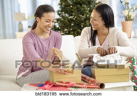 Mother and daughter wrapping Christmas gifts View Large Photo Image Stock Photography - Mother and daughter wrapping Christmas gifts. Fotosearch