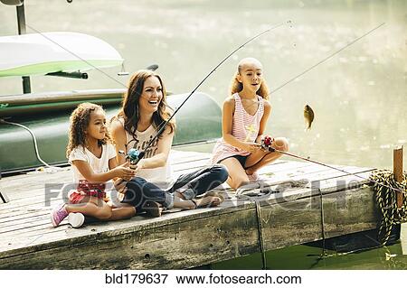 Stock Photo - Mother and daughters fishing in lake. Fotosearch