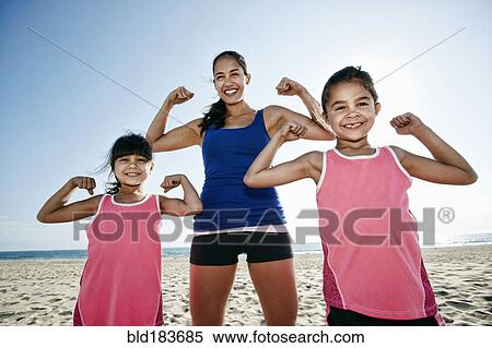 Mother and daughters flexing muscles at beach View Large Photo Image Stock Photography - Mother and daughters flexing muscles at beach. Fotosearch