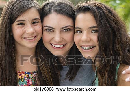 Stock Photo - Mother and daughters smiling outdoors. Fotosearch
