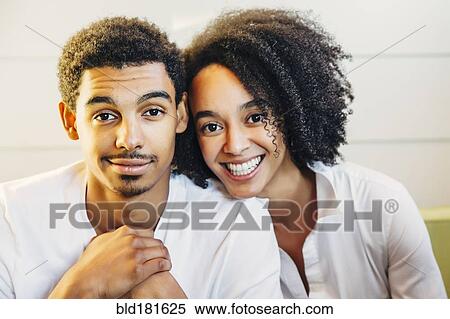 Stock Photography - Mother and son smiling on sofa. Fotosearch