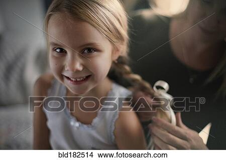 Mother braiding hair of daughter View Large Photo Image Picture - Mother braiding hair of daughter. Fotosearch