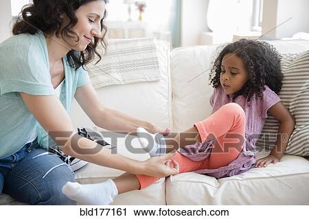 Mother helping daughter put on socks View Large Photo Image Stock Image - Mother helping daughter put on socks. Fotosearch