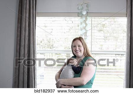 Mother holding baby son at window View Large Photo Image Stock Photo - Mother holding baby son at window. Fotosearch