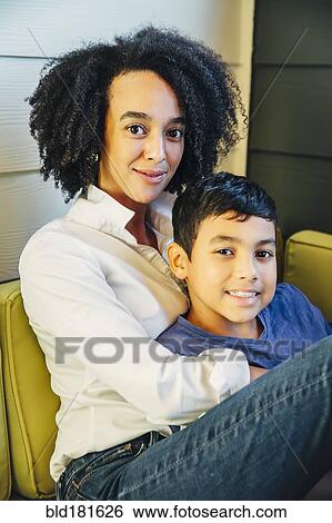 Mother hugging son on sofa View Large Photo Image Stock Photograph - Mother hugging son on sofa. Fotosearch
