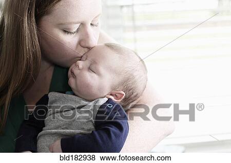 Stock Photo - Mother kissing baby son. Fotosearch