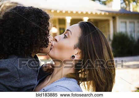 Stock Photography - Mother kissing son outdoors. Fotosearch